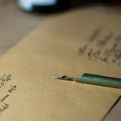 Plume et encre sur papier kraft. On peut écrire famille sur une enveloppe pour envoyer des nouvelles.