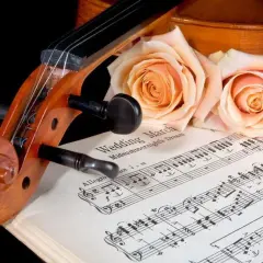 Violon posé sur des partitions de "Wedding March", orné de roses. Une belle évocation d'un mariage thème musique.