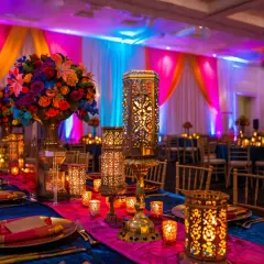 Décoration d'inspiration Bollywood, lanternes ajourées, bougies scintillantes et fleurs éclatantes sur une table dressée. Une ambiance féerique à faire soi-même.