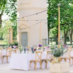Une belle allée de mariage extérieur, décorée de tables dressées, de fleurs et de guirlandes lumineuses, invite à la célébration.