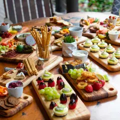 Plateaux variés pour un thème pour nouvel an : mini-cheesecakes, fruits, charcuterie, crevettes et grissini.