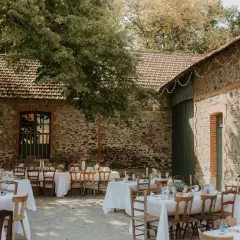 Tables dressées pour un mariage thème champêtre, sous les arbres et à l'ombre des vieilles pierres.