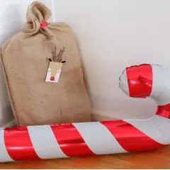 Un sac de Père Noël et un ballon de baudruche en forme de canne à sucre, symbolique de Noël.