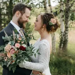 Un couple souriant, bouquet de mariage classique à la main. Idéal pour un texte remerciement mariage classique.