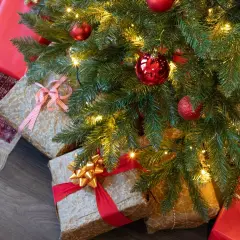 Idée tuto sapin de noël : des cadeaux emballés sous un sapin décoré de boules rouges et de guirlandes lumineuses.