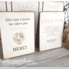 Un **livre** d'or et une carte "Aidez-nous à boucler nos valises pour l'Île Maurice" sur une table en bois, décorés de fleurs séchées.