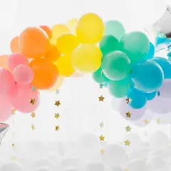 Arc-en-ciel de ballons colorés, une idée déco avec ballon à gonfler pour une fête joyeuse. Étoiles dorées suspendues.