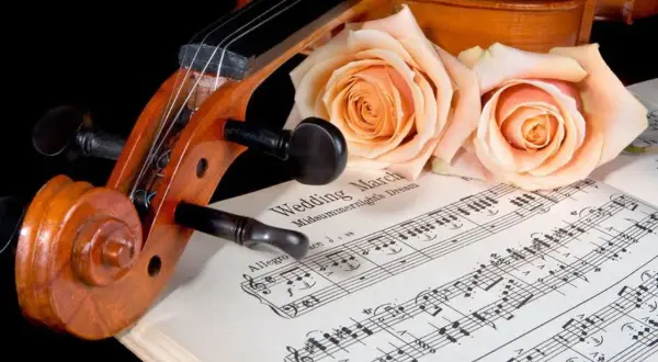Violon posé sur des partitions de "Wedding March", orné de roses. Une belle évocation d'un mariage thème musique.