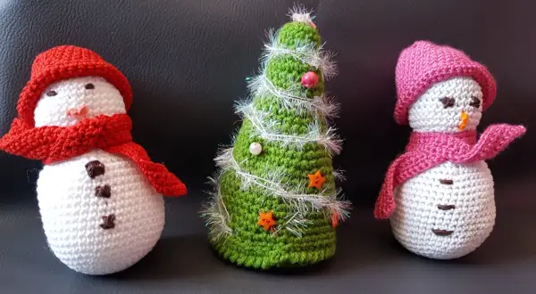 Trois adorables bonhommes de neige et un sapin de Noël tricotés, parfaits pour une déco de Noël. Modèle gratuit déco noël au tricot.