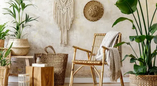 Ambiance bohème avec une chaise en rotin, paniers tressés, macramé et plantes vertes. Une **exotique déco des îles à faire soi même** pour un coin détente.