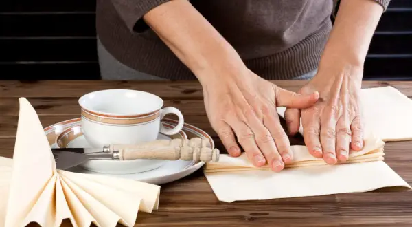 Mains expertes en pliage serviette papier 40x40 pour une table élégante.