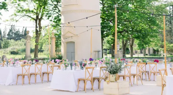 Une belle allée de mariage extérieur, décorée de tables dressées, de fleurs et de guirlandes lumineuses, invite à la célébration.