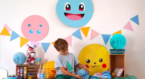 Décoration Pokémon à faire soi-même pour une fête : Pikachu, Rondoudou et Carapuce souriants, guirlandes colorées et un garçon émerveillé.