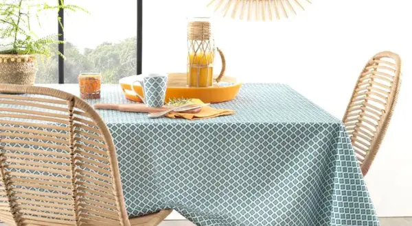 Table dressée avec une nappe à motifs géométriques bleus et blancs. Idéal pour savoir quelle couleur de nappe choisir pour un style frais et naturel.