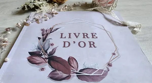Livre d'or orné de feuillages et fleurs, entouré d'une guirlande perlée. Une belle idée pour remplir un livre d'or de souvenirs précieux.