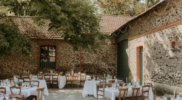 Tables dressées pour un mariage thème champêtre, sous les arbres et à l'ombre des vieilles pierres.