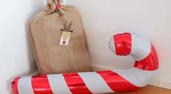 Un sac de Père Noël et un ballon de baudruche en forme de canne à sucre, symbolique de Noël.