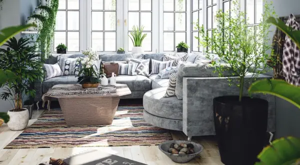 Un salon lumineux et aéré, baigné de lumière naturelle, avec un canapé d'angle confortable, des plantes luxuriantes et une décoration au thème bucolique.