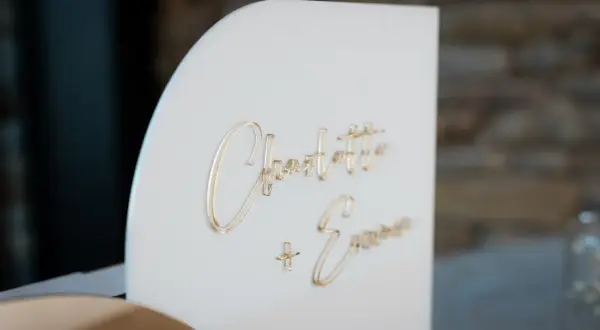 Boîte à enveloppe blanche avec les noms "Charlotte + Emma" en lettres dorées.