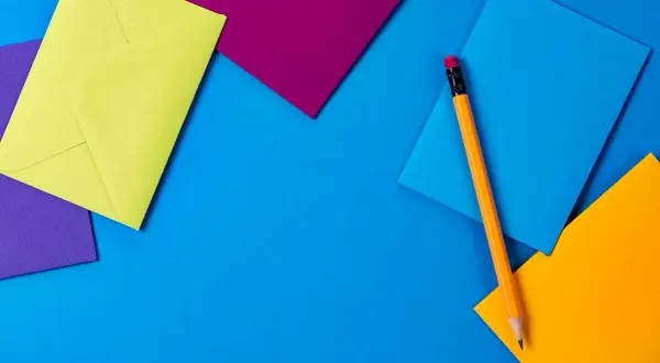 Enveloppes colorées et crayon, prêts pour une sms invitation apéro.