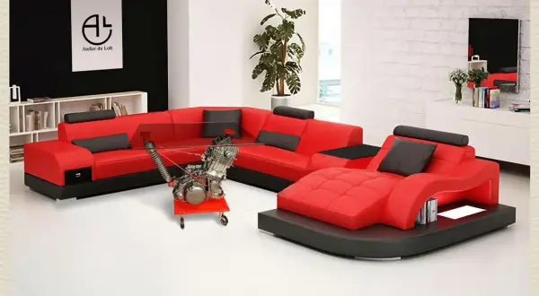 Salon moderne avec canapé rouge et noir, table basse originale intégrant un moteur de moto. Une déco table moto unique pour les passionnés.