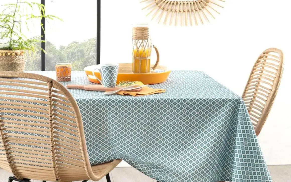 Table dressée avec une nappe à motifs géométriques bleus et blancs. Idéal pour savoir quelle couleur de nappe choisir pour un style frais et naturel.