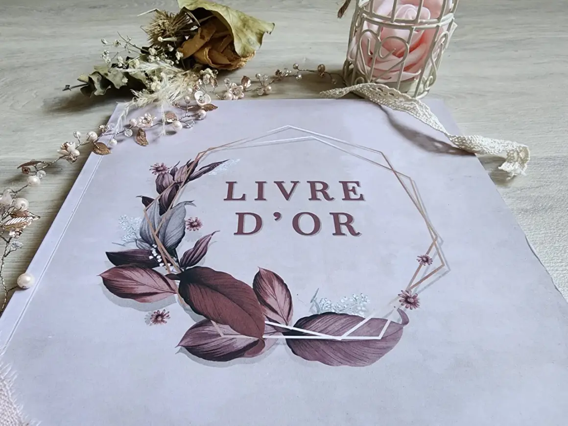 Livre d'or orné de feuillages et fleurs, entouré d'une guirlande perlée. Une belle idée pour remplir un livre d'or de souvenirs précieux.