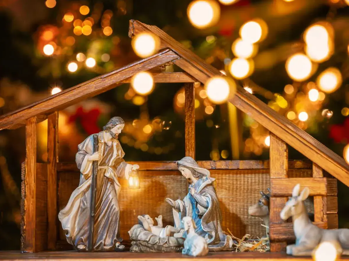 Une id&eacute;e cr&egrave;che de No&euml;l originale : Joseph, Marie et l'enfant J&eacute;sus dans une &eacute;table illumin&eacute;e par des guirlandes scintillantes.