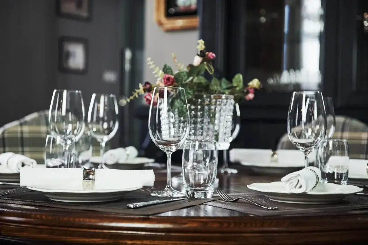 Table dress&eacute;e pour un repas : assiettes, serviettes, couverts et un verre &agrave; vin droite ou gauche.