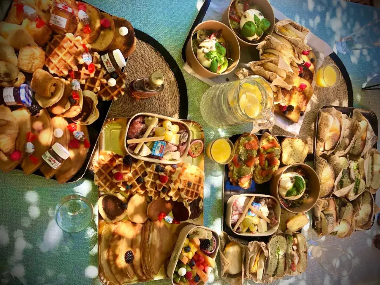 Un festin pour l'heure du brunch dimanche : gaufres, crêpes, Nutella, fruits, sandwiches et jus frais.