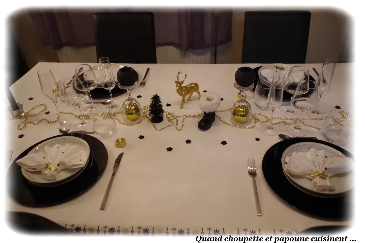 Table dressée pour un réveillon festif, avec des verres, des boules dorées et une figurine de renne. Un thème pour nouvel an élégant et scintillant.