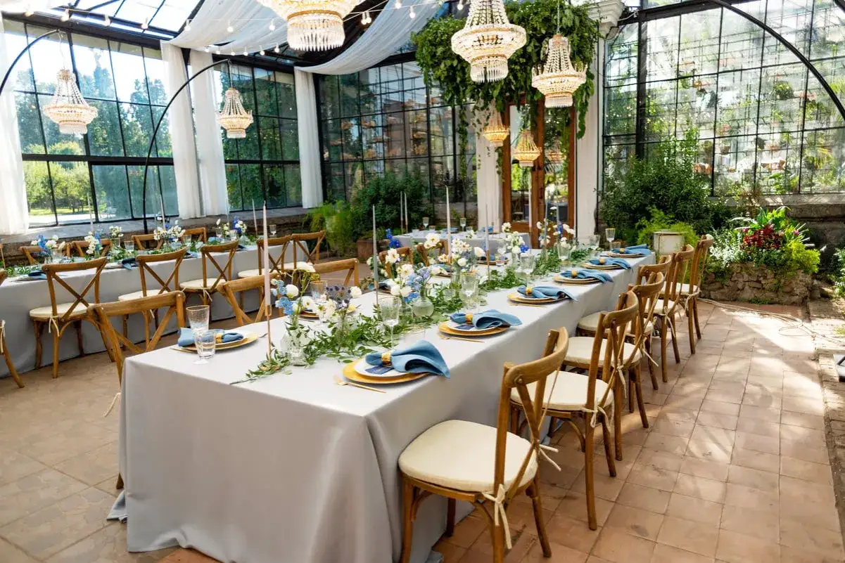 Tables dressées pour 50 personnes, avec nappes grises, serviettes bleues et fleurs. Combien de mètre de nappe pour 50 personnes ?