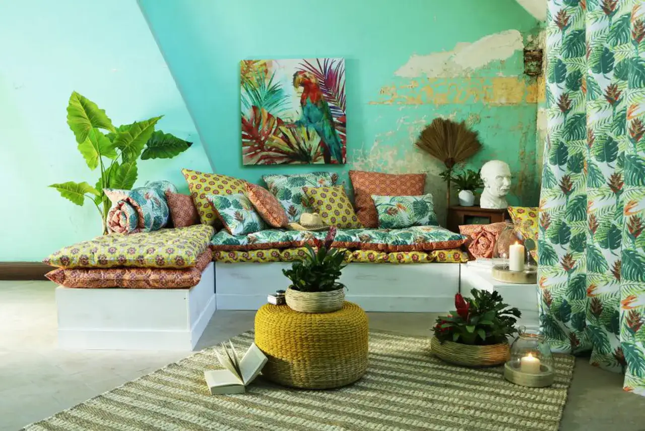 Salon aux couleurs tropicales, inspiration pour une deco antillaise a faire soi meme. Canapé modulable, coussins aux motifs végétaux et perroquet.