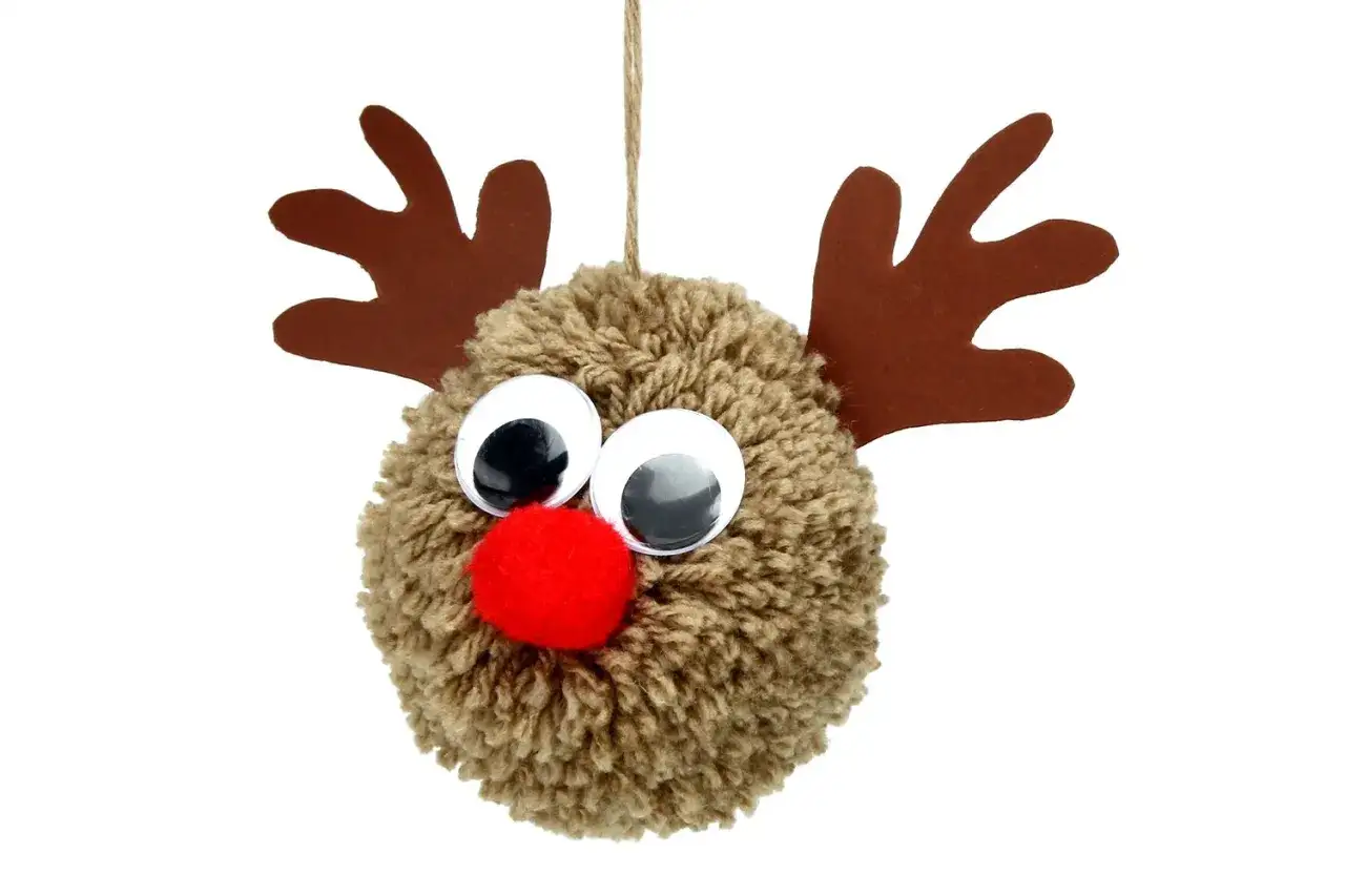 Adorable renne fait main pour fabriquer Père Noël en pompon de laine. Ses grands yeux brillants et son nez rouge le rendent irrésistible.