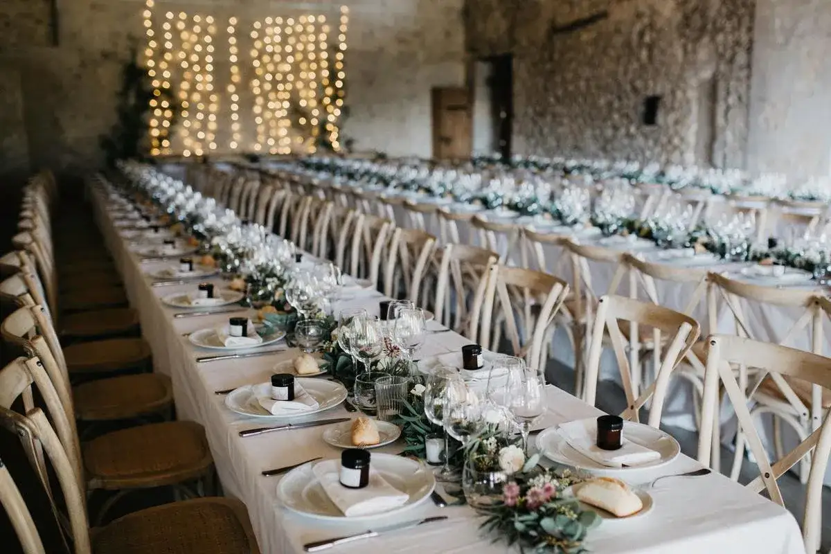Long tables dress&eacute;es pour un mariage champ&ecirc;tre, avec des petites attentions sur chaque assiette pour remplacer les drag&eacute;es.