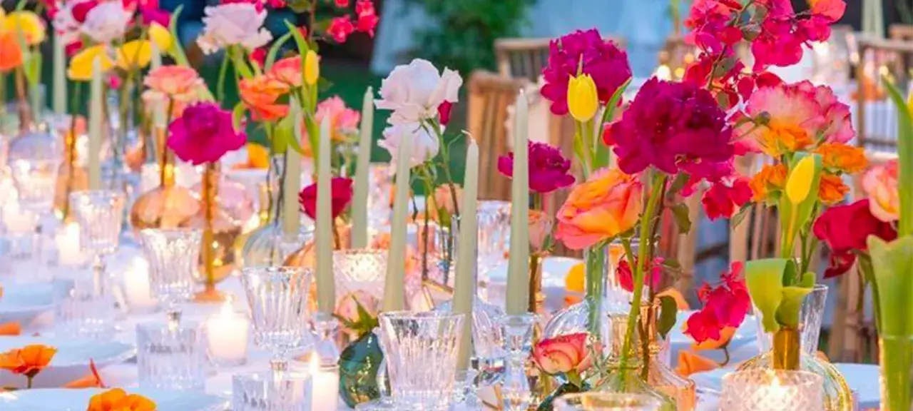 Table dress&eacute;e avec des fleurs vives et des bougies. La couleur de mariage et signification se refl&egrave;tent dans ce bouquet joyeux.
