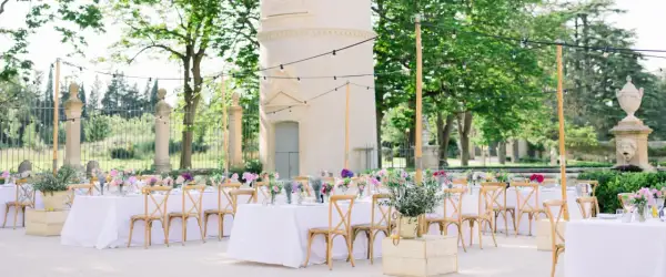 Une belle allée de mariage extérieur, décorée de tables dressées, de fleurs et de guirlandes lumineuses, invite à la célébration.