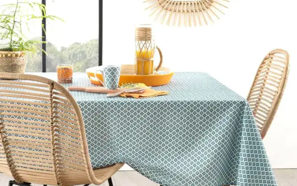 Table dressée avec une nappe à motifs géométriques bleus et blancs. Idéal pour savoir quelle couleur de nappe choisir pour un style frais et naturel.