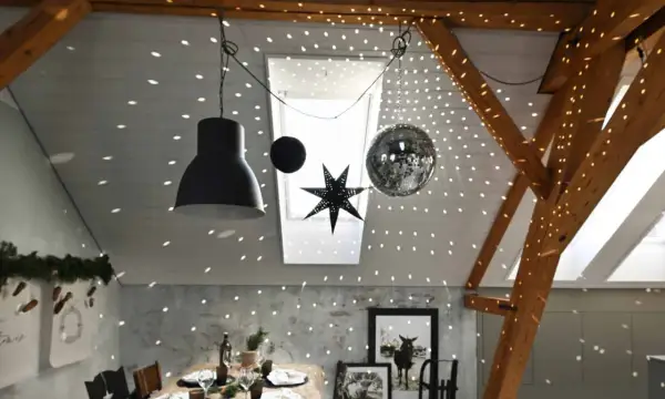 Une boule disco et une étoile décorent le plafond, projetant des lumières scintillantes. Une excellente idee deco plafond noel pour une ambiance festive.