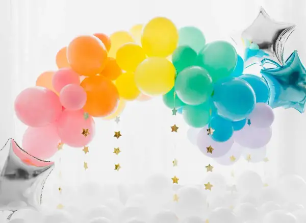 Arc-en-ciel de ballons colorés, une idée déco avec ballon à gonfler pour une fête joyeuse. Étoiles dorées suspendues.